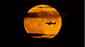 plane in front of moon